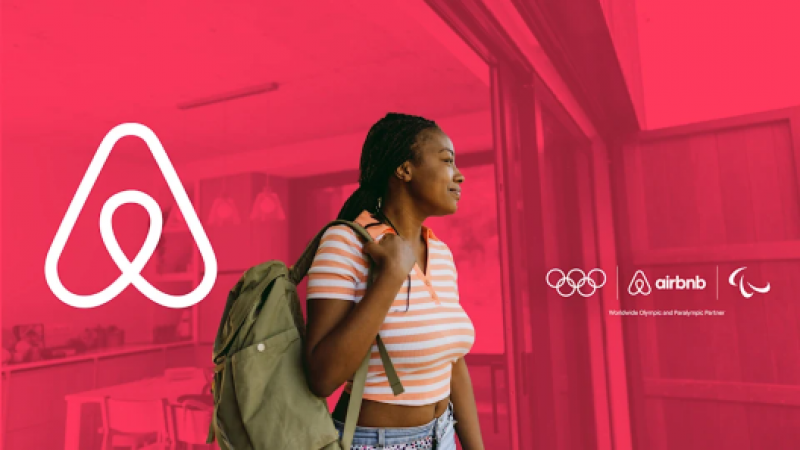 An Airbnb banner with the IOC and IPC logos and a photograph of a woman