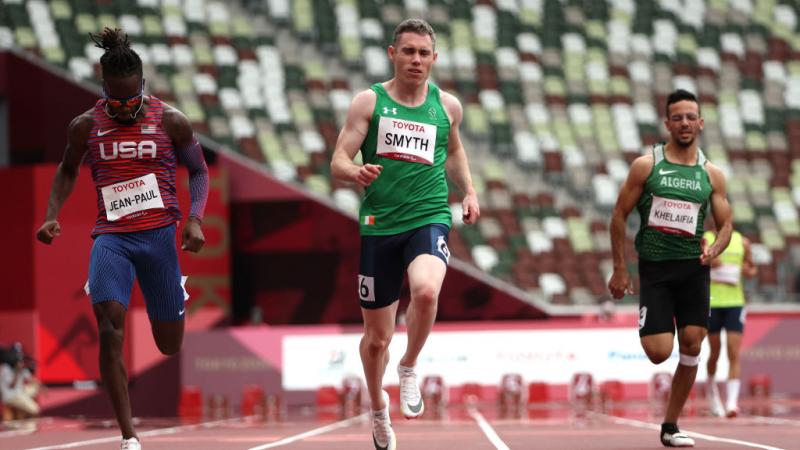 Three male athletes compete in a race.