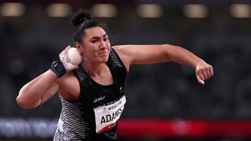 A female shot put athlete competes in a stadium