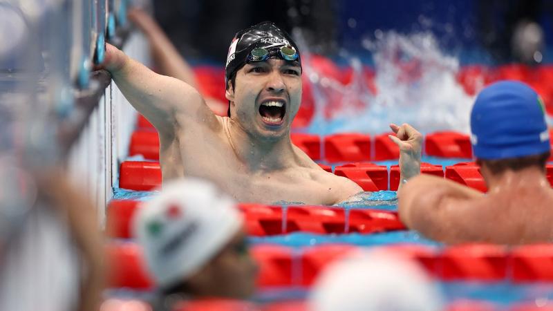 A male swimmer celebrates after touching the wall at the Tokyo 2020 Paralympics.