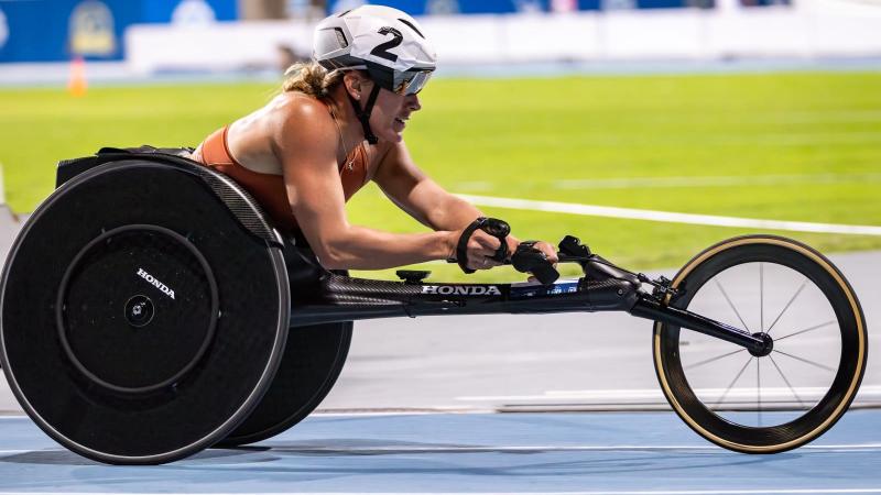 A female wheelchair racer on a blue athletics track