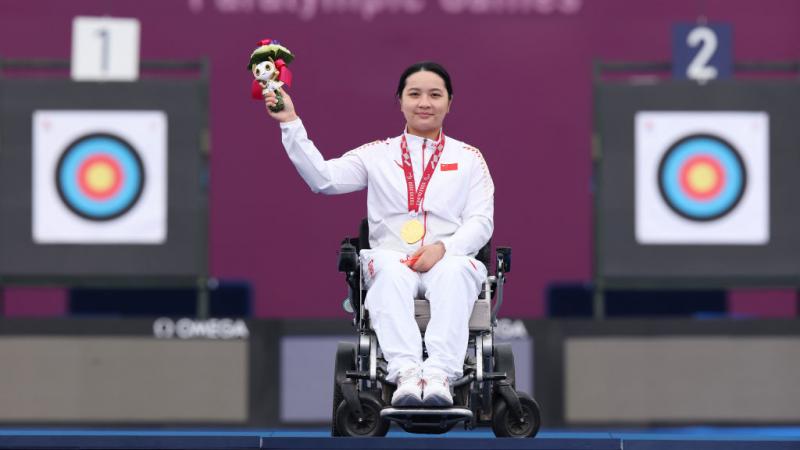 Para archer Chen Minyi celebrates her gold medal on the podium 