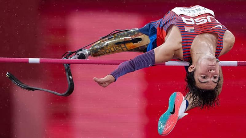 Ezra Frech jumps backwards over the high bar displaying his prosthetic leg