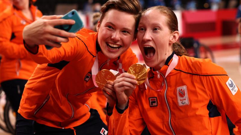 Two Dutch women's wheelchair basketball players take a selfie with their gold medals.