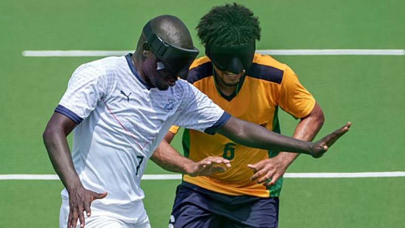 blind footballer Babacar Niang holds off another player from the ball 