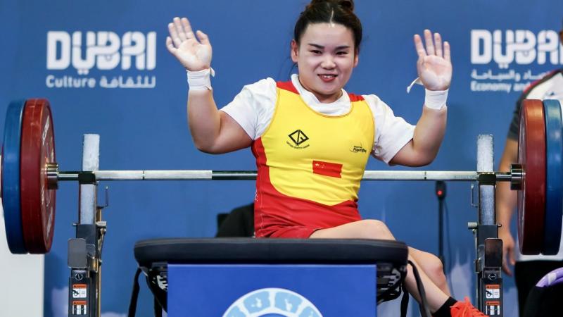 A female powerlifter waving on the bench press