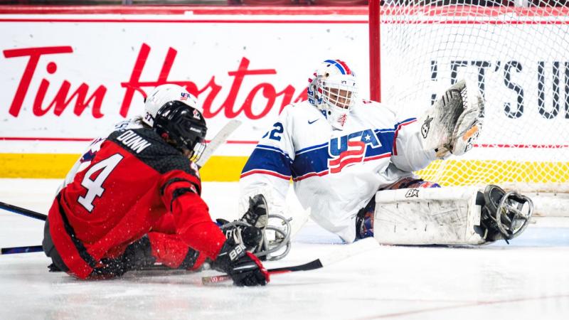 A hockey goaltender making a save from an opponent's shot