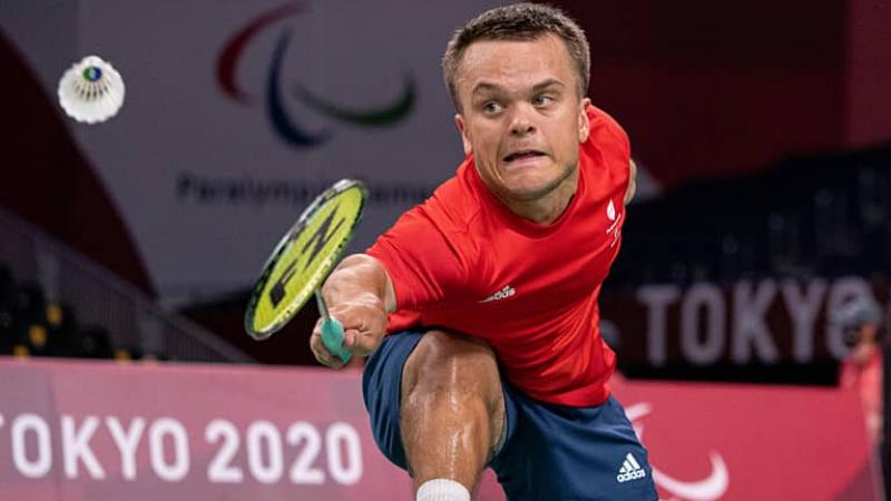 Para badminton player Jack Shephard bends down to hit the shuttlecock