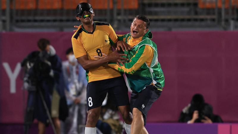 Brazilian blind footballer Raimundo Mendes celebrates a goal with his coach