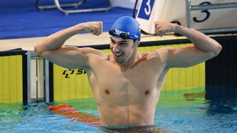 A male swimmer showing his arms in the pool