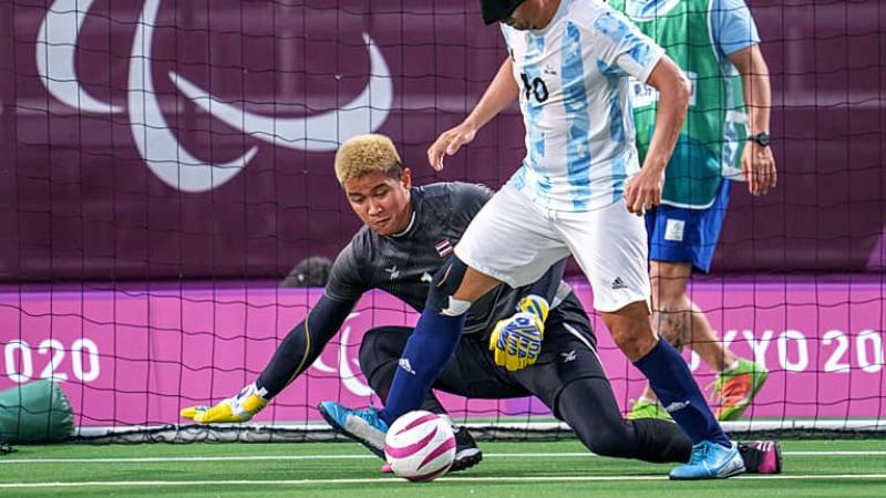 a blind footballer takes a shot that is saved by a sighted goalkeeper