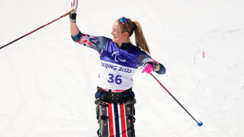 Para skier Birgit Skarstein waves and smiles from her sit-ski 