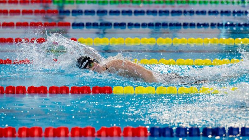 A female swimmer competing in the freestyle stroke