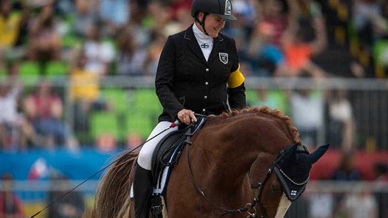 Para rider Katja Karjalainen smiling on her horse 