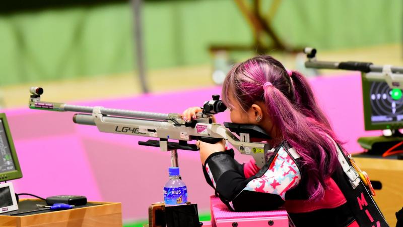 A female Japanese athlete with pink hair competes at Tokyo 2020