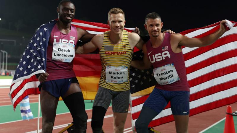 Three men with prosthetic legs posing for a picture in a competition