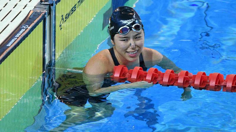 A swimmer reacts after her performance