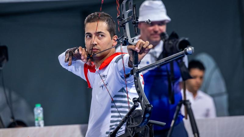 A male Para archer aims at a target during competition