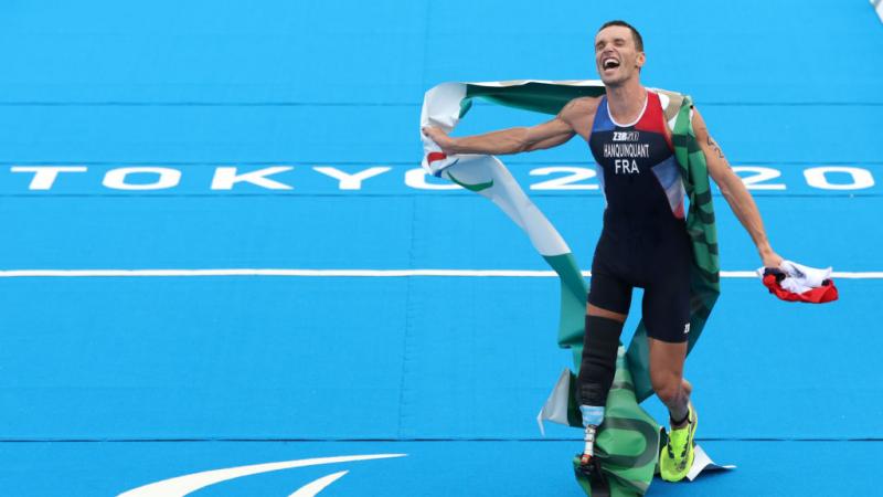 A male triathlete reacts after winning his race at the Tokyo 2020 Paralympics