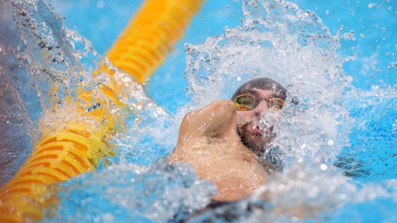 An armless man swimming backstroke