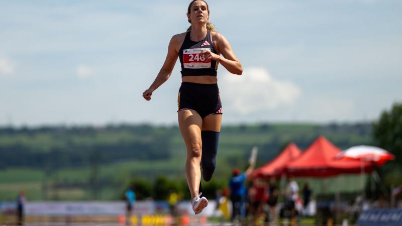 A female athlete with a prosthetic leg crossing the finish line