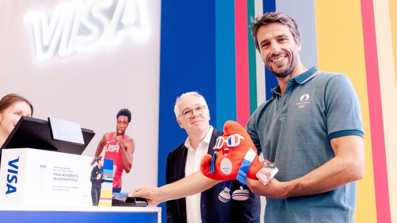 Paris 2024 President Tony Estanguet poses for a photograph while holding the Games mascot Phryge at the megastore