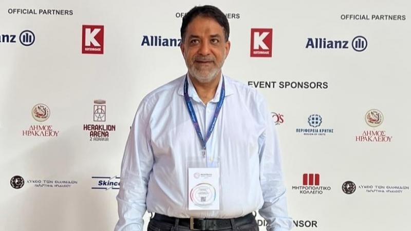 A man standing with backdrop behind him