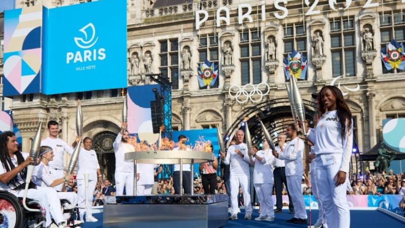 Torchbearers stand around the Paralympic flame in the centre of Paris