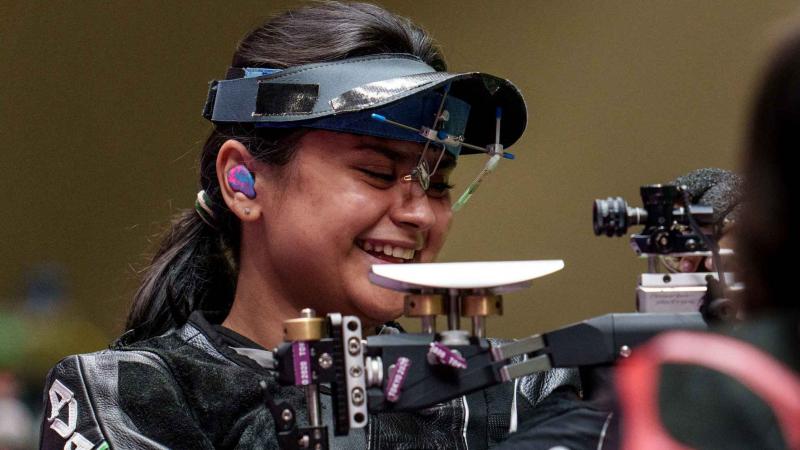 An athlete gestures after winning a rifle event 