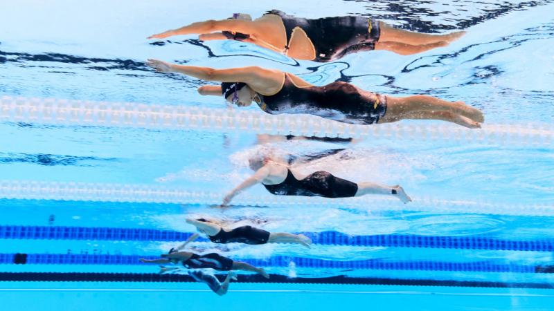 An underwater image of four female swimmers in a pool