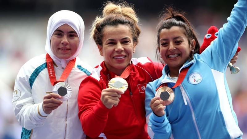 Three female short statures athletes showing their medals
