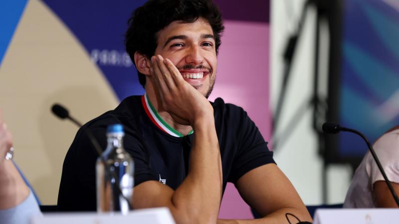 A man with a hand on his face during a press conference