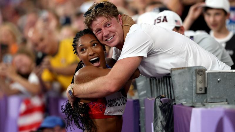 A female athlete hugging a man on trackside