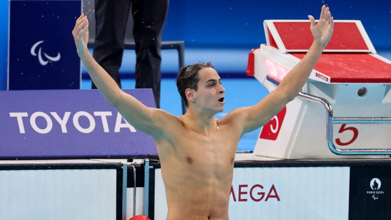 Ugo Didier holds his arms out wide as the crowd cheers 
