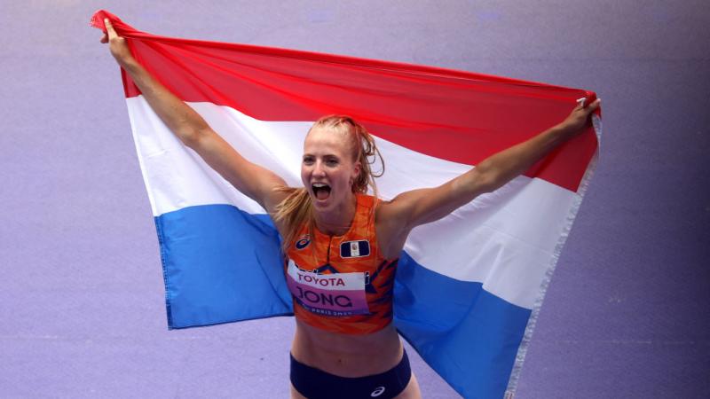Para athlete Fleur Jong cheers holding up the Dutch flag 
