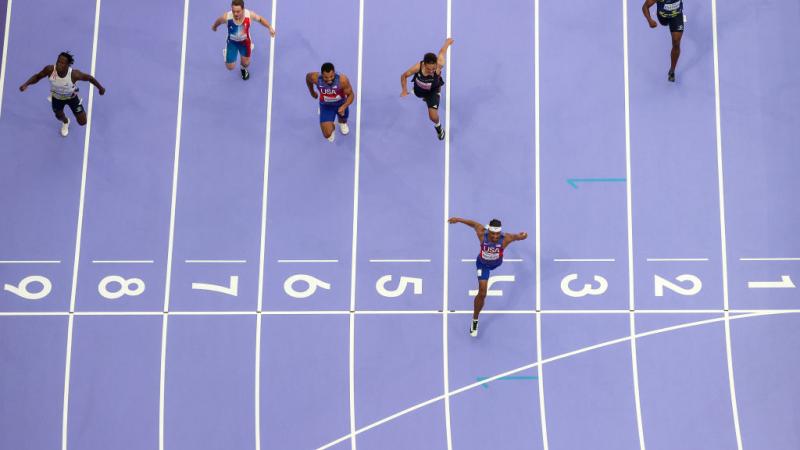 An athlete crossing the finish line well ahead the other runners