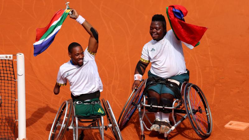 Donald Ramphadi and Lucas Sithole wave South African flags on court