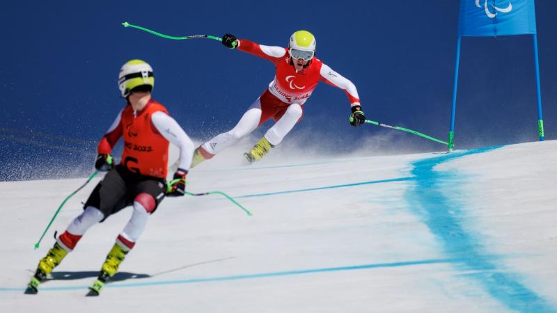 A male alpine skier follows his guide skier during competition