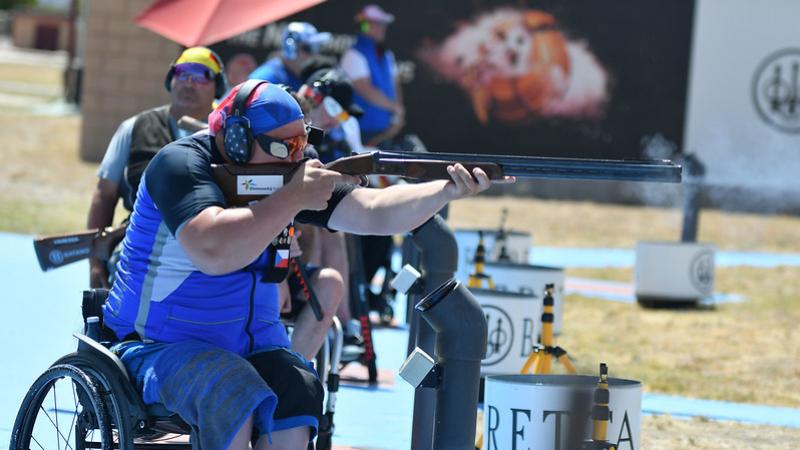 A man in a wheelchair competing in a Para trap shotgun event