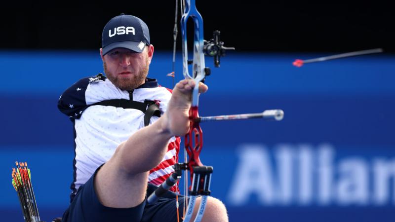 A male Para archer without arms shoots an arrow with his foot