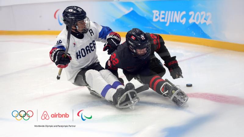 A banner with a photo of Para ice hockey players in action with the logo of Airbnb