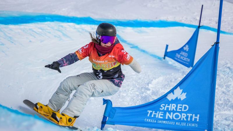 A female Para snowboarding athlete in action