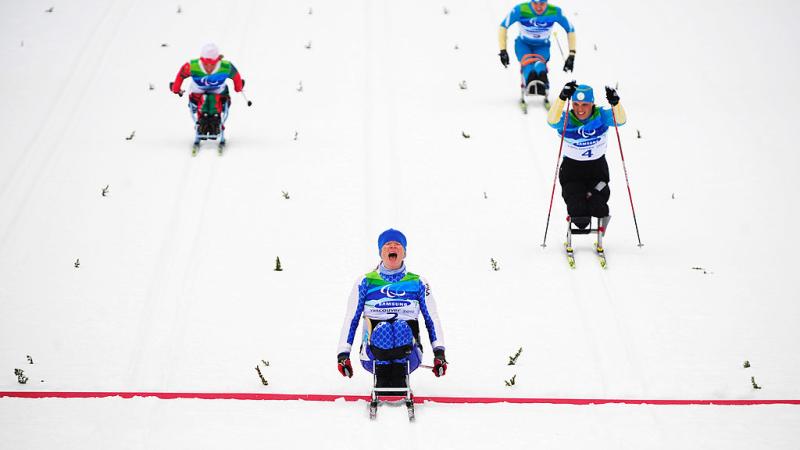 Four Para cross-country sit-skiers in action. Francesca Porcellato, who is in the centre of the image, reacts after crossing the red line