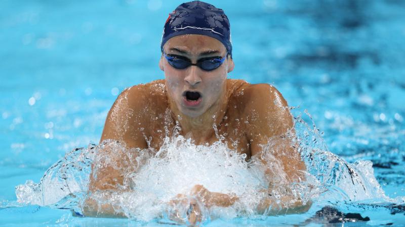 A male Para swimmer swimming breaststroke