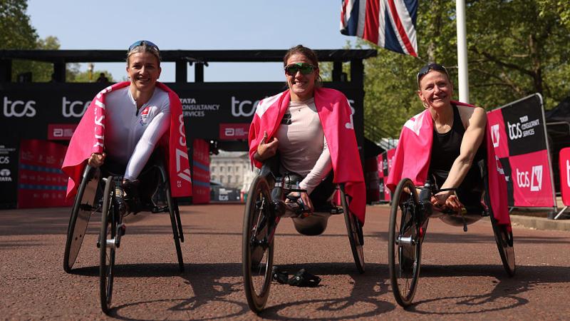 Three female wheelchair racers posing for pictures after the London Marathon