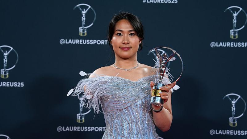 Yuyan Jiang smiles for a photo while holding the Laureus trophy with her left hand
