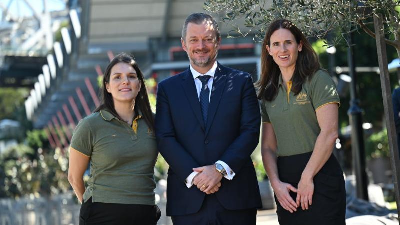 IPC President Andrew Parsons and two female Paralympians wearing Australia's green polo shirt are posing for a photo