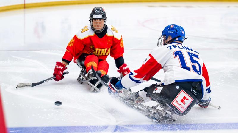 A Chinese Para ice hockey player in front of a Czech player