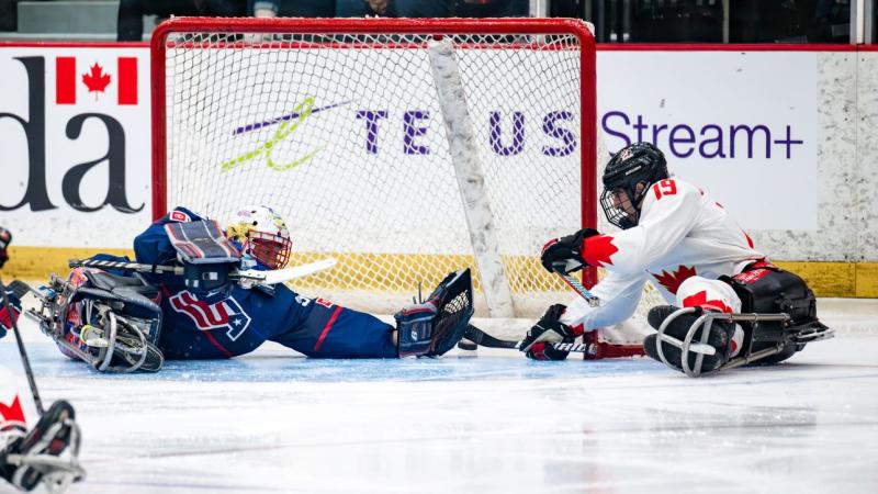A Canadian Para ice hockey player scoring a goal against USA goaltender
