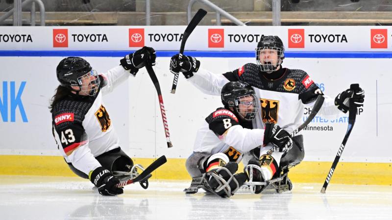 Three German Para ice hockey players celebrating a goal